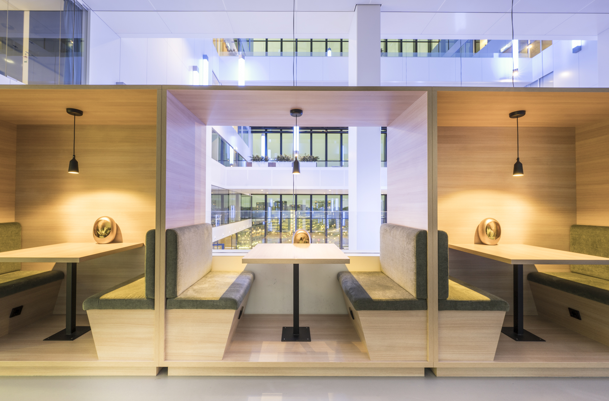 Moderne zithoeken met tafels en banken in een stijlvol, verlicht interieur.