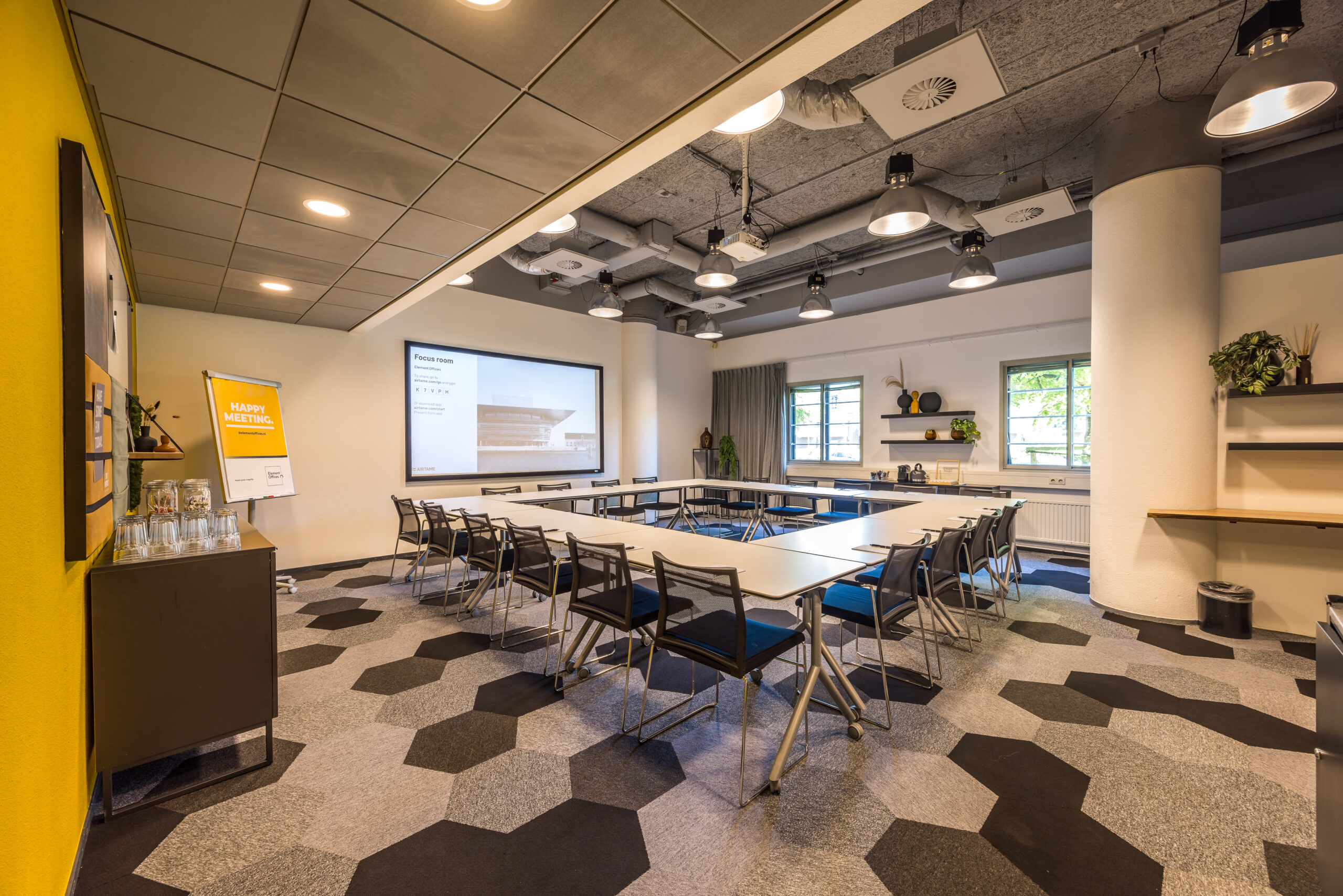 Een moderne vergaderruimte in Element Offices, Utrecht, met een U-vormige tafelopstelling en gele accenten.