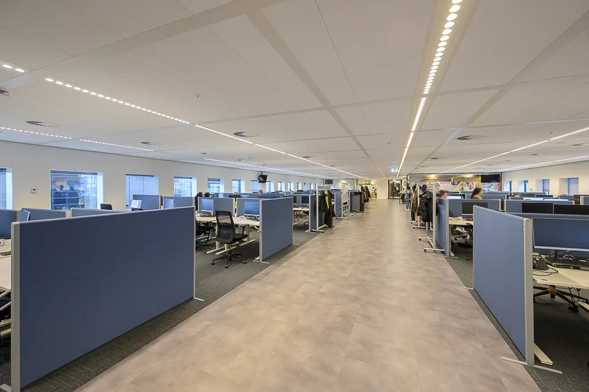 Ruim, modern kantoorpand aan het Weena met open werkplekken en blauwe scheidingswanden.
