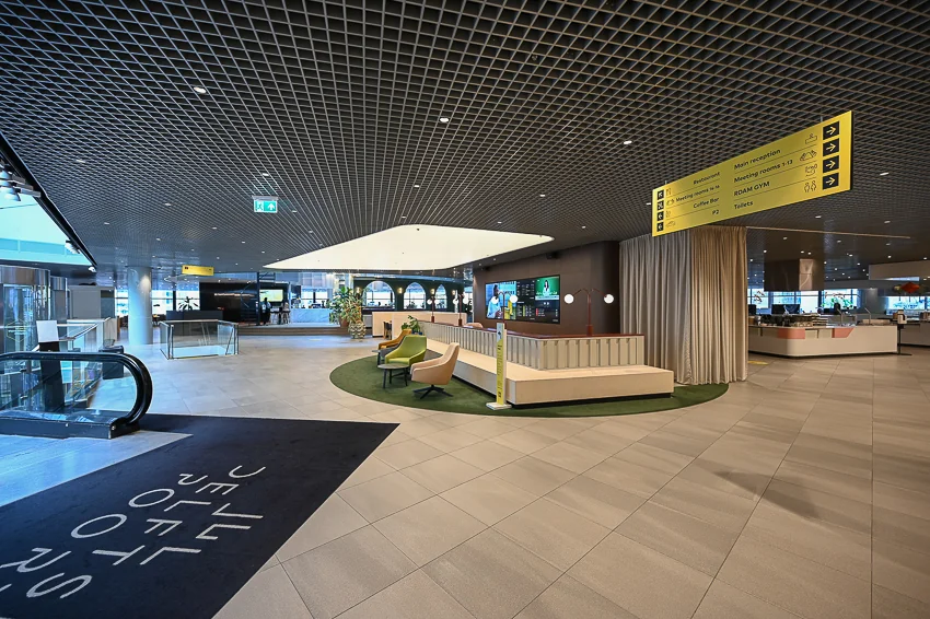 Moderne en ruime lobby van het kantoorgebouw aan het Weena met zitgedeelte en duidelijke bewegwijzering.
