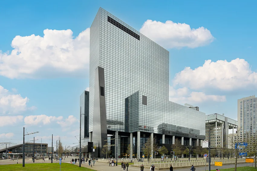 Hoog, modern kantoorgebouw aan het Weena in Rotterdam met een gevel van spiegelend glas.