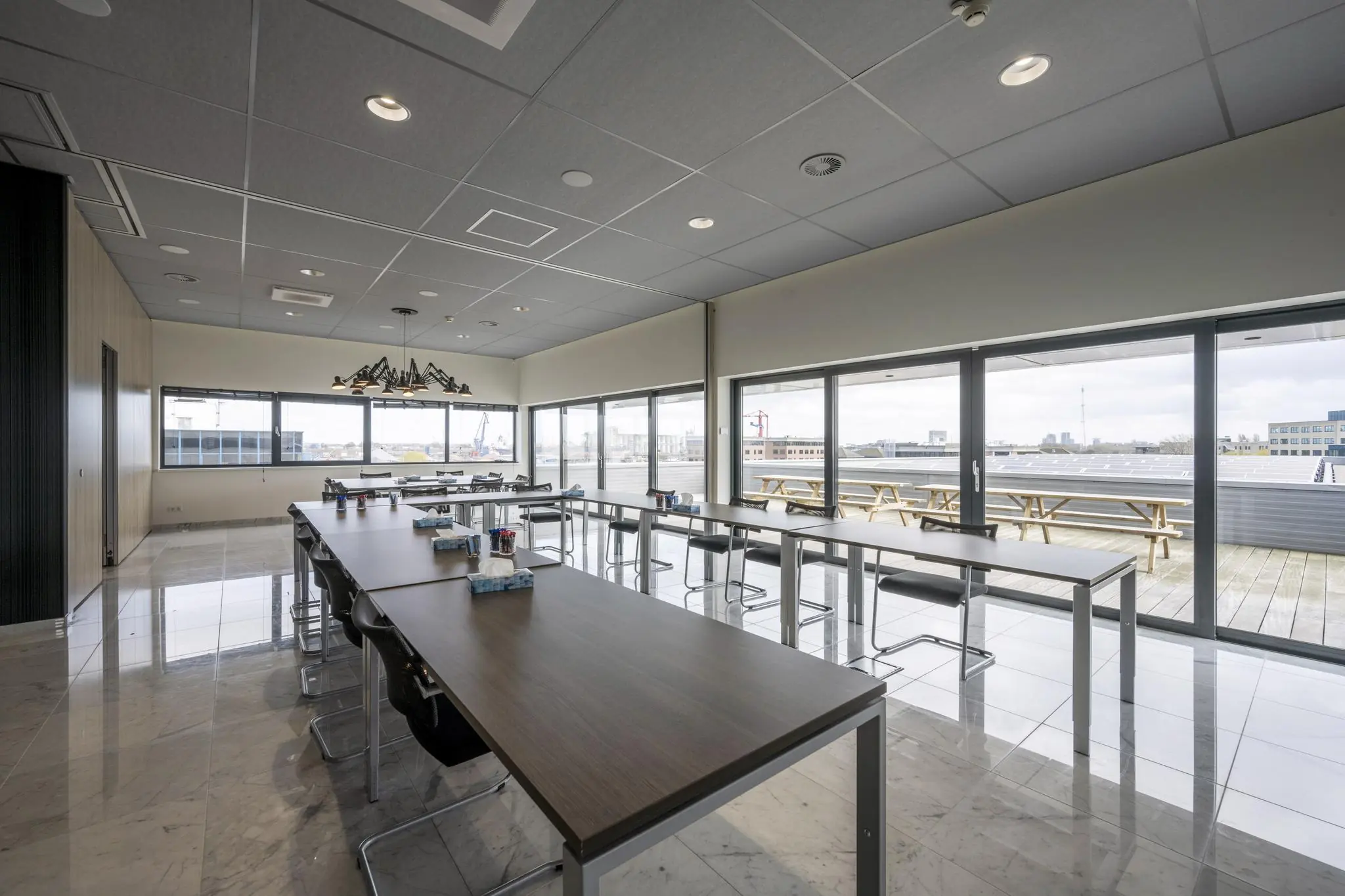 Vergaderruimte met moderne inrichting en uitzicht op een buitenterras aan de Dynamostraat.