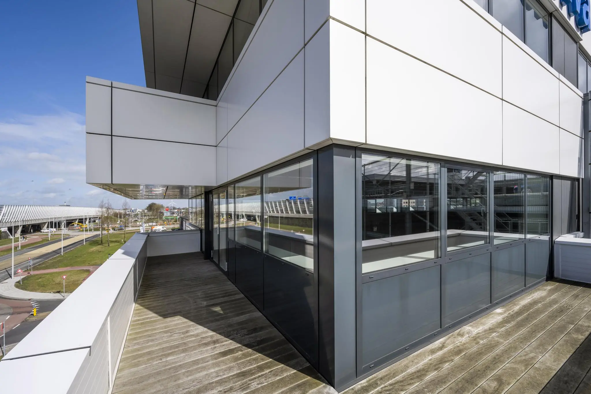 Modern kantoorgebouw aan de Dynamostraat met glazen gevel en ruim balkon.