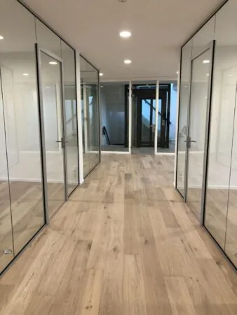 Gerenoveerde kantoorruimte aan het Concertgebouwplein met glazen wanden en houten vloer.