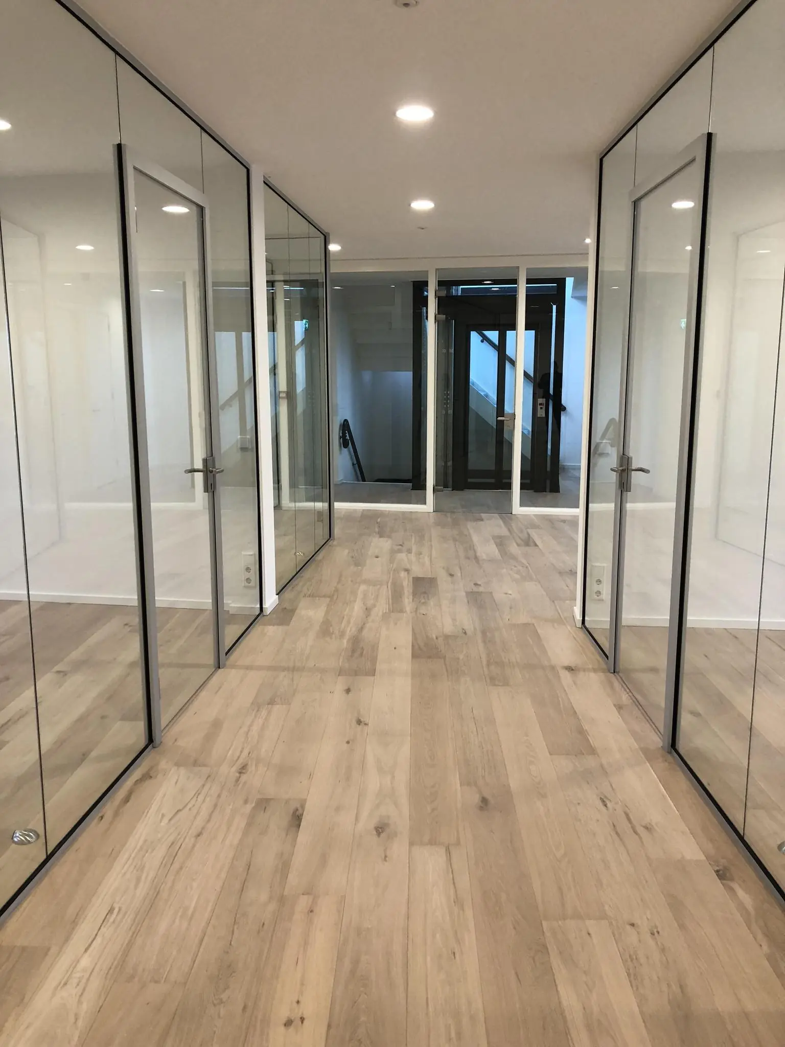 Gerenoveerde kantoorruimte aan het Concertgebouwplein met glazen wanden en houten vloer.