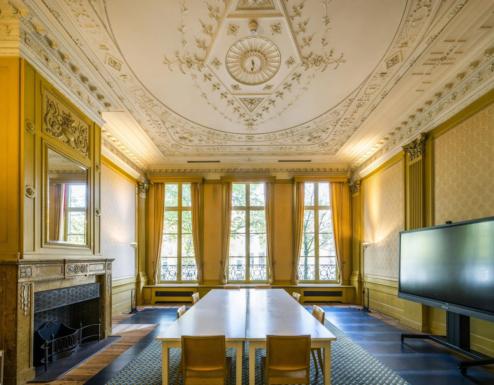Vergaderruimte aan de Herengracht met hoge plafonds, klassieke ornamenten en grote ramen met uitzicht op de gracht.