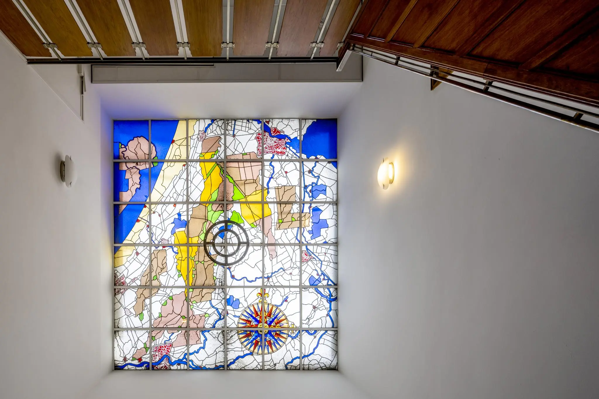 Glas-in-lood plafond met kleurrijke kaart van Nederland in een trappenhuis aan de Herengracht.