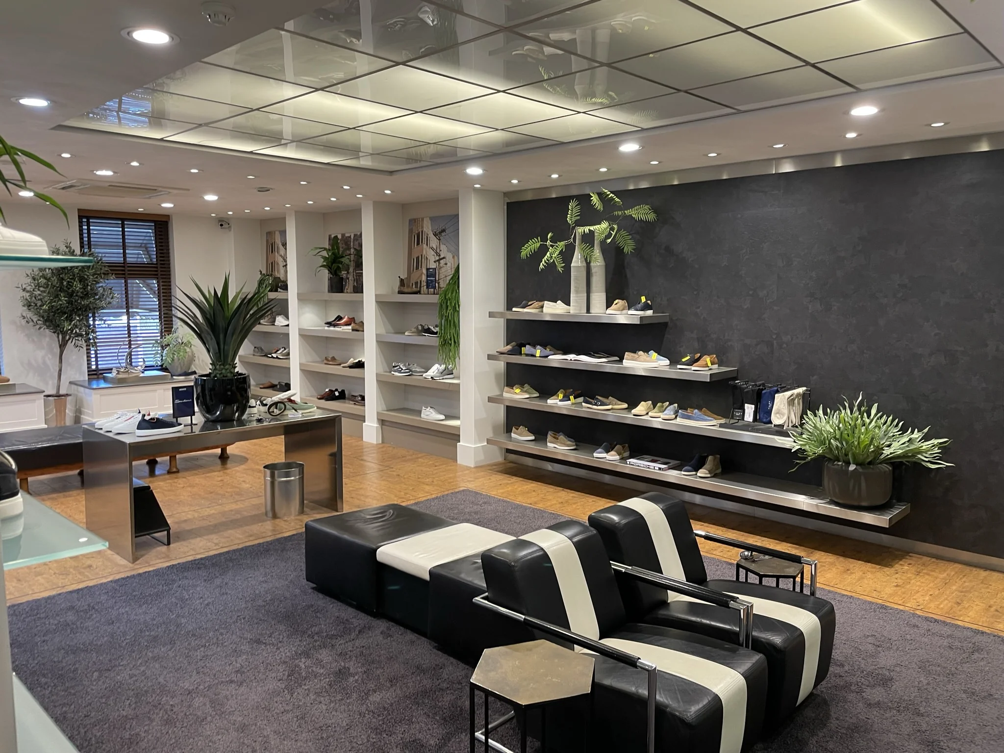 Moderne en sfeervolle schoenenwinkel aan de Molendijk met stijlvolle inrichting, zitgelegenheid en schoenen uitgestald op wandplanken.