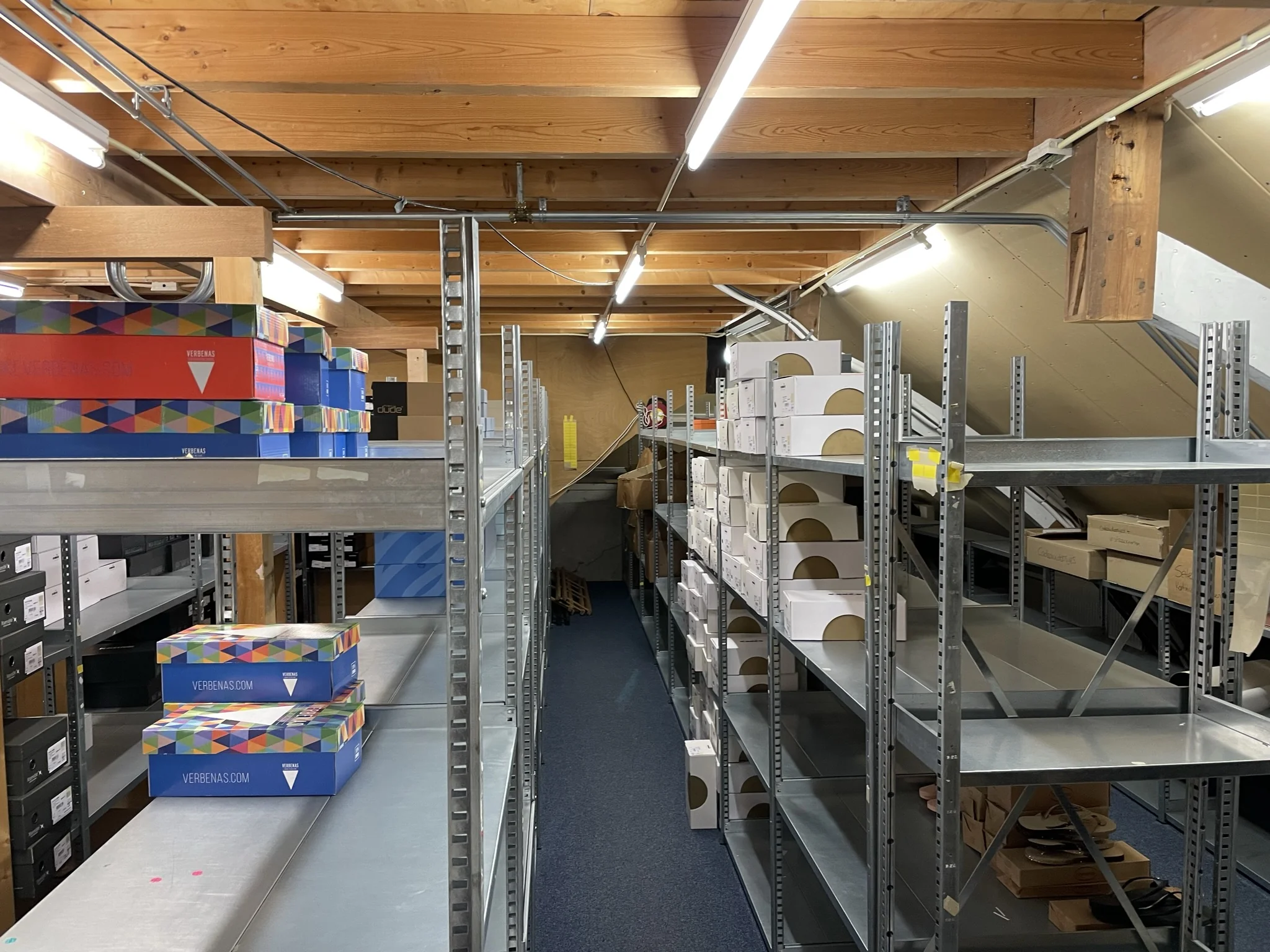 Metalen stellingkasten gevuld met schoenendozen in een opslagruimte op de Molendijk.