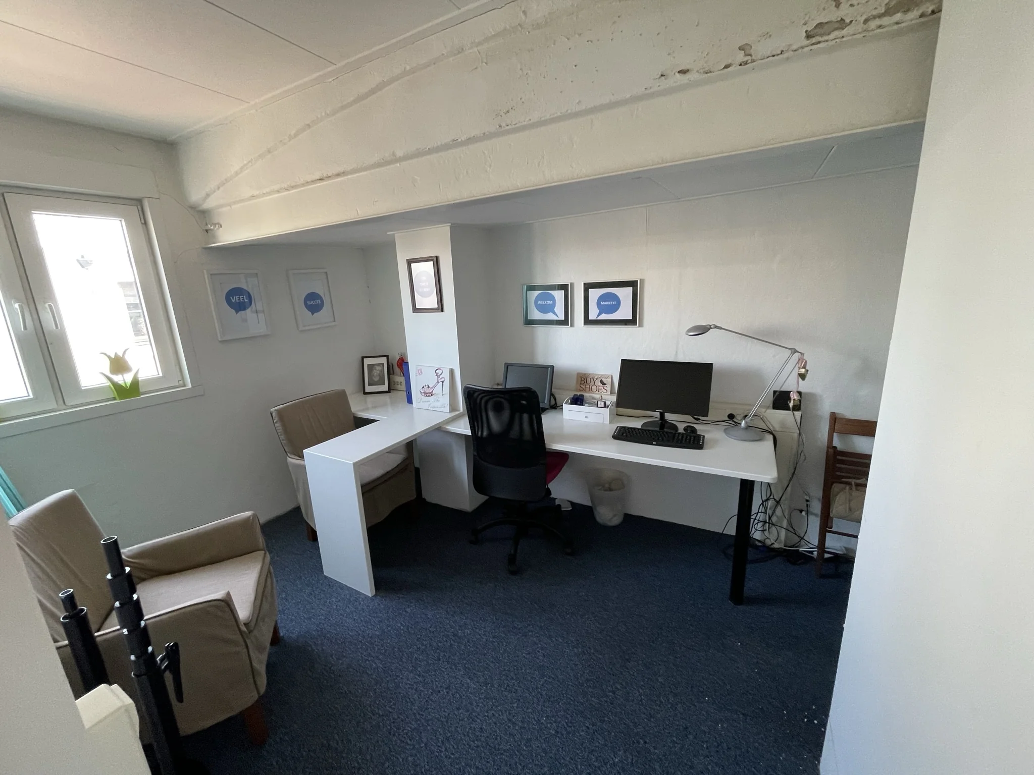 Kleine kantoorruimte aan de Molendijk met twee werkplekken, bureaustoelen, computers en motiverende posters aan de muur.