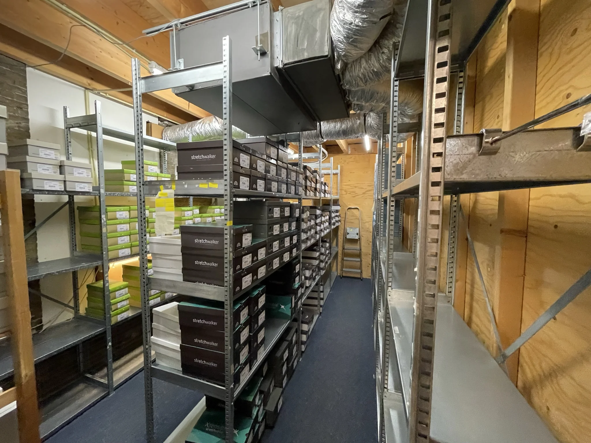 Opslagruimte met metalen stellingen vol schoenendozen van het merk Stretchwalker in magazijn Molendijk.