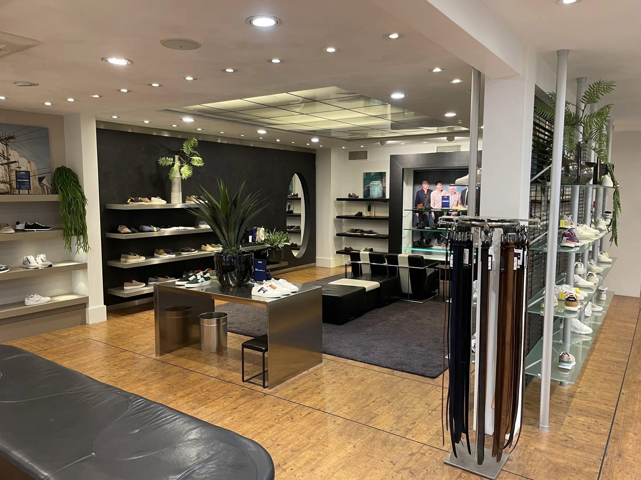 Moderne en stijlvolle schoenenwinkel aan de Molendijk, met overzichtelijke schappen vol sneakers, leren riemen en een gezellige zithoek.