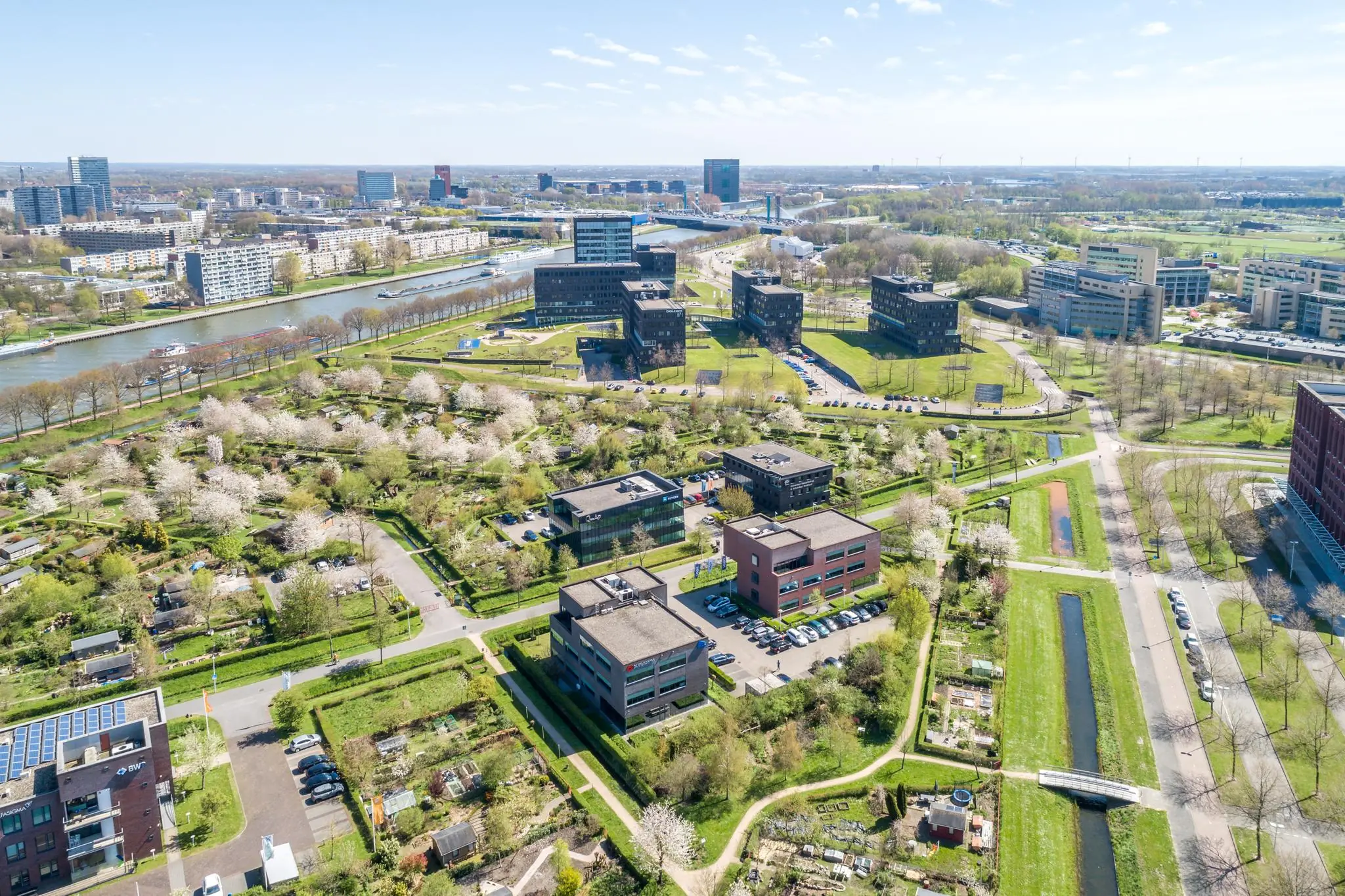 Luchtfoto van de Groenewoudsedijk in Utrecht met kantoorgebouwen, volkstuinen en het Amsterdam-Rijnkanaal.