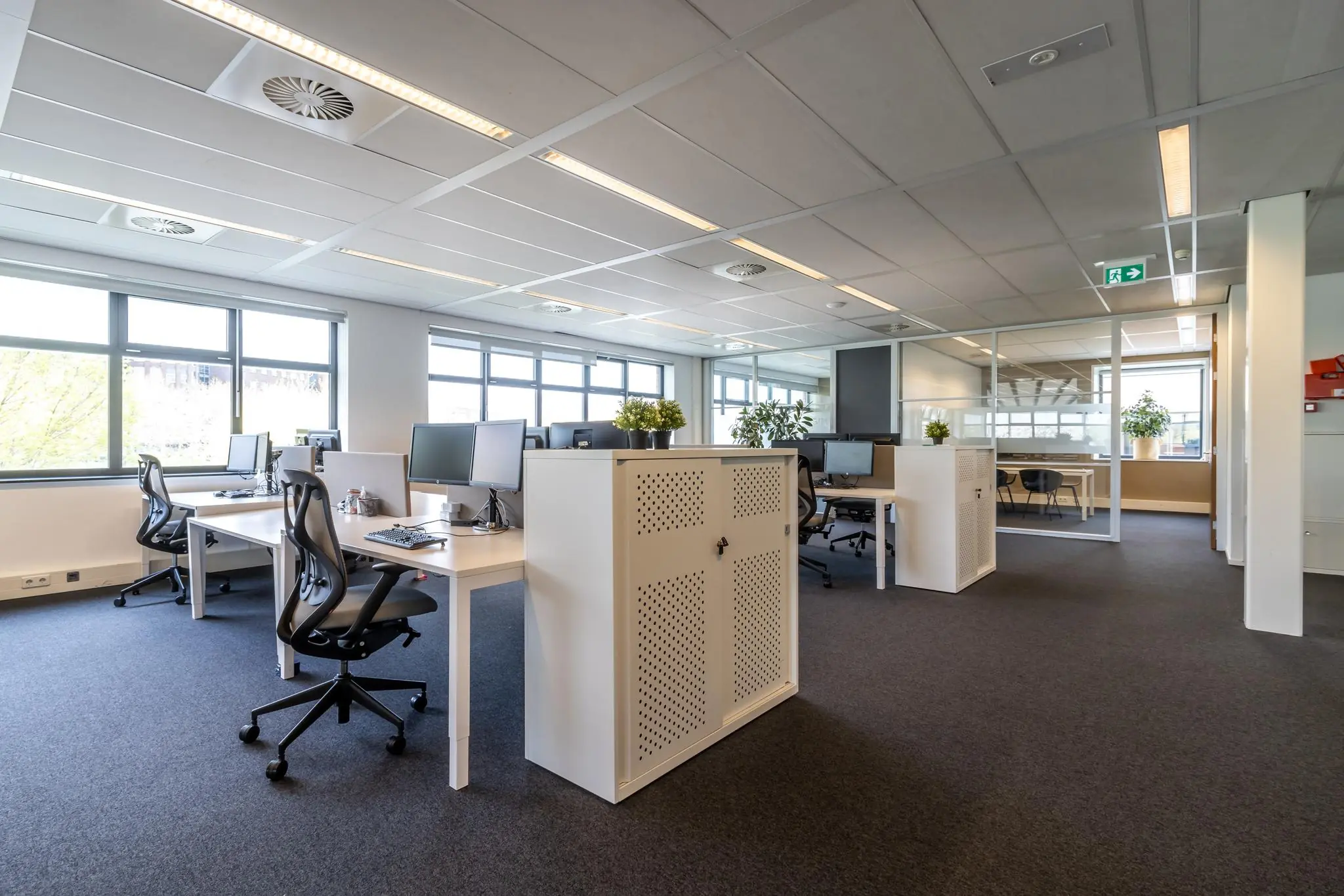 Modern en licht kantoorpand aan de Groenewoudsedijk met open werkplekken en grote ramen.