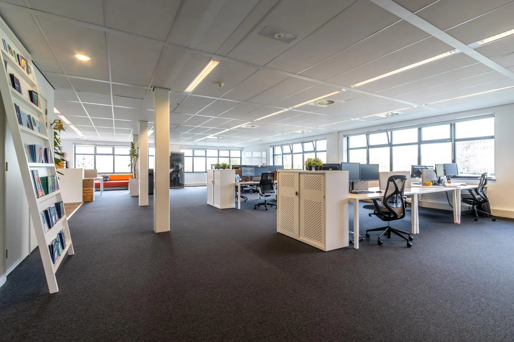 Ruim en licht kantoorinterieur aan de Groenewoudsedijk met moderne werkplekken en grote ramen.