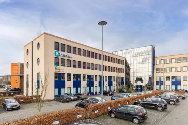 Kantoorgebouw aan de Fokkerstraat in Leusden met parkeerplaatsen op de voorgrond.