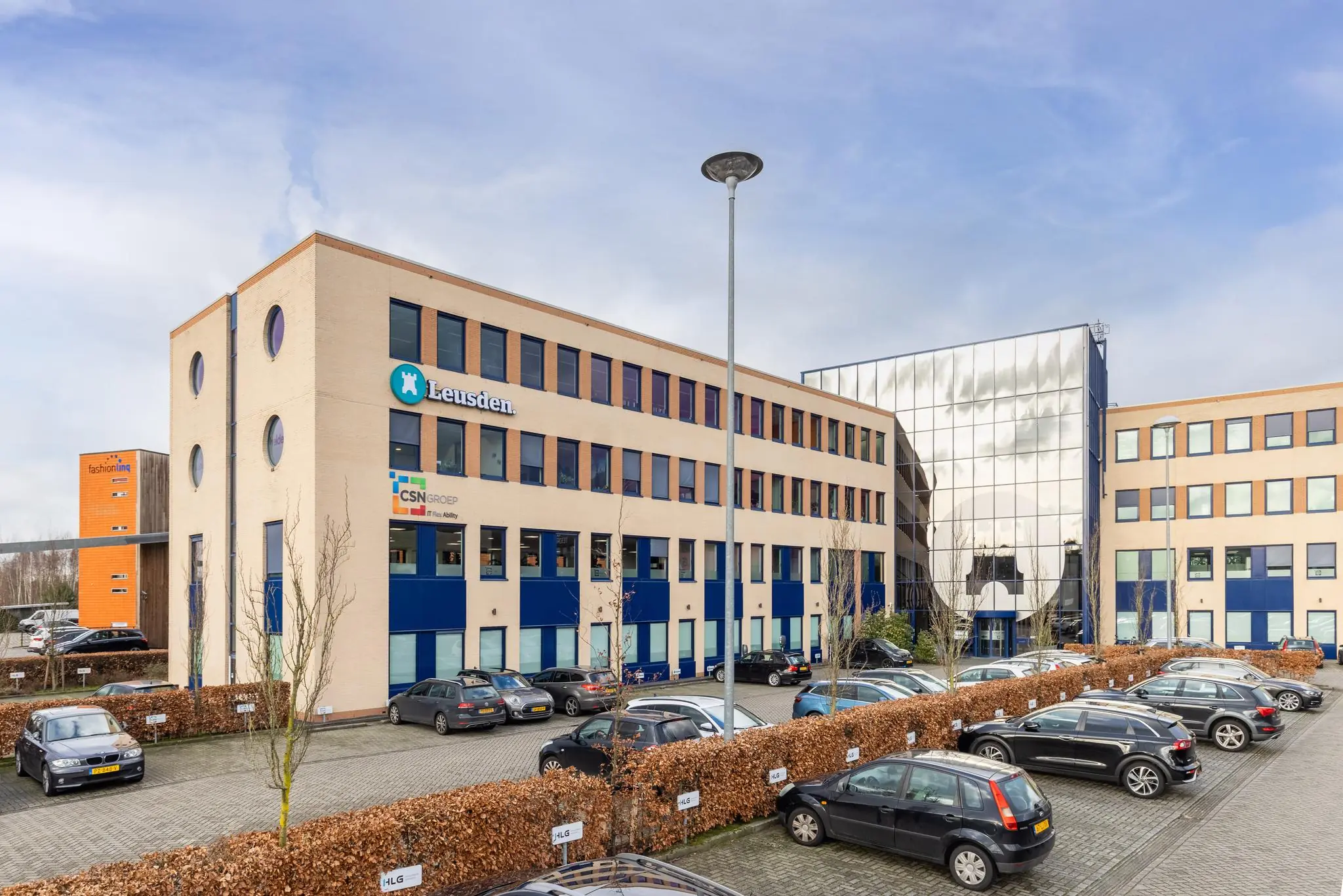 Kantoorgebouw aan de Fokkerstraat in Leusden met parkeerplaatsen op de voorgrond.