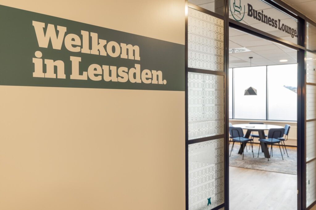 Ingang van een moderne business lounge in Leusden met welkomsttekst op de muur.
