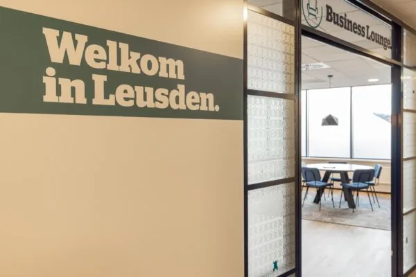 Ingang van een moderne business lounge in Leusden met welkomsttekst op de muur.