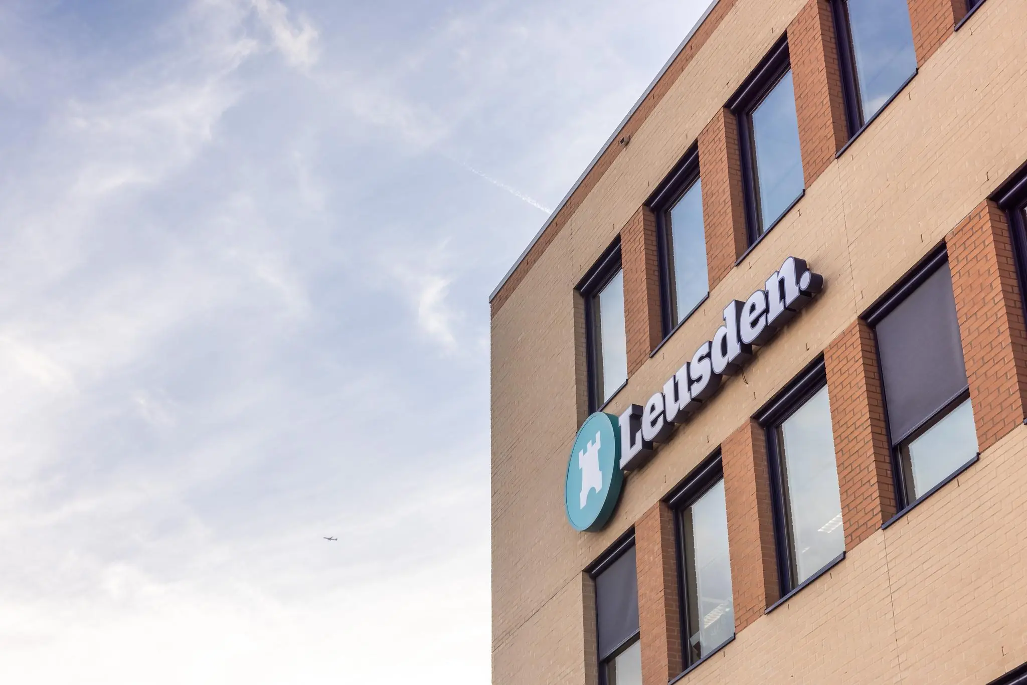 Vooraanzicht van een kantoorgebouw met het logo en de naam "Leusden" op de gevel aan de Fokkerstraat.