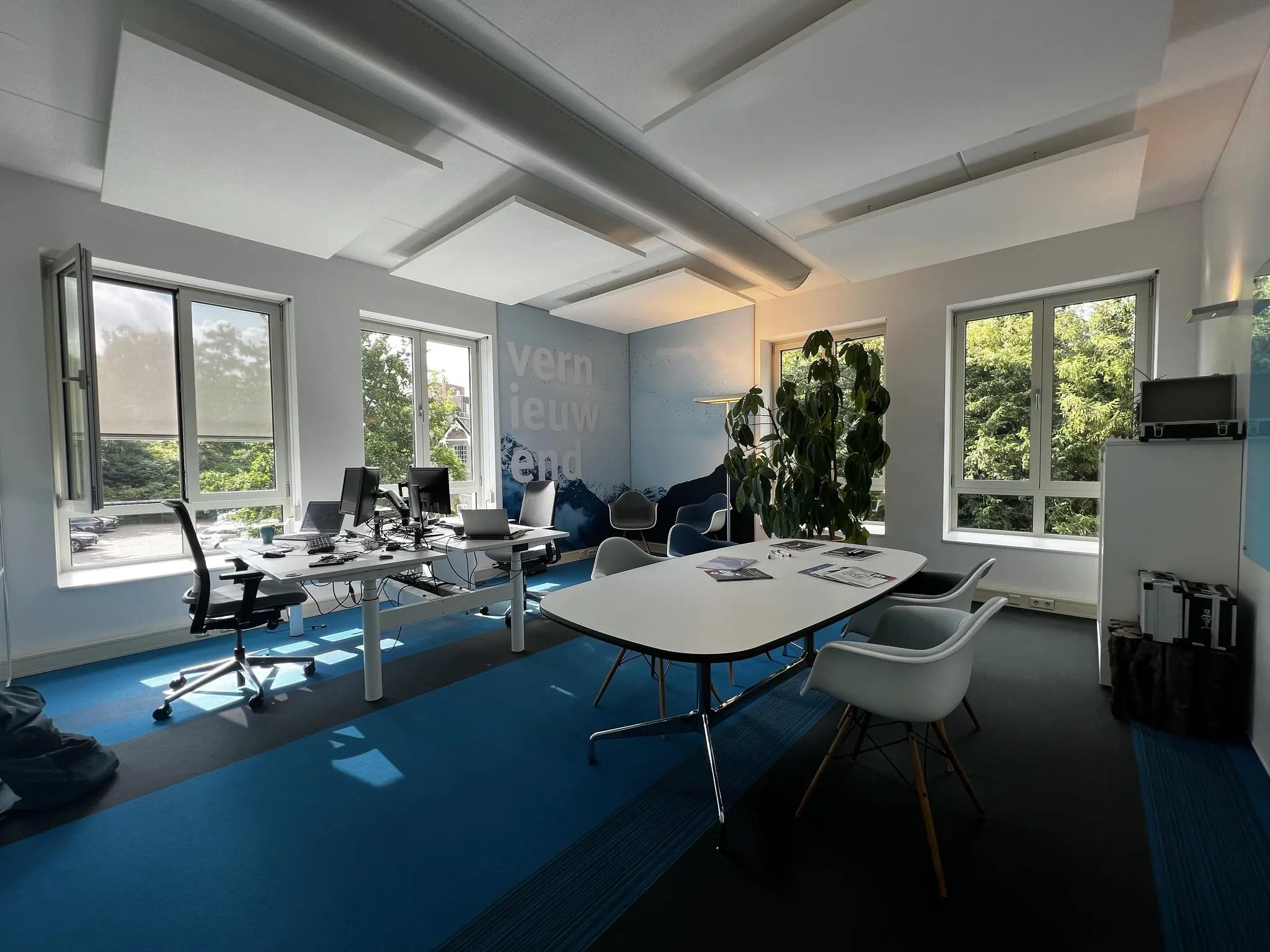 Modern kantoor met bureaus, vergadertafel en grote ramen aan de Driebergseweg.