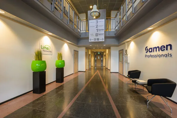 Entreehal van een kantoorpand aan de Bahialaan met logo’s van Lime Networks en Samen Professionals aan de muren.