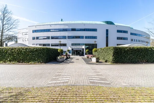 Vooraanzicht van het moderne kantoorgebouw Sparrenheuvel B met een strak aangelegde entree en groenvoorziening.