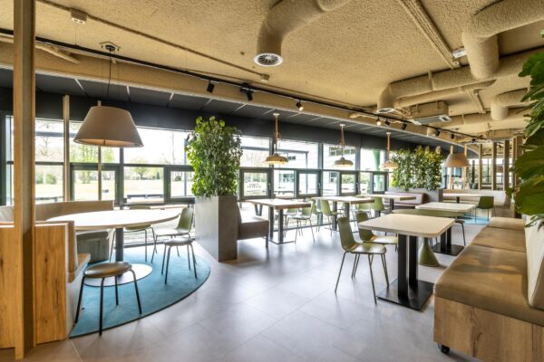 Moderne, licht ingerichte kantine van Sparrenheuvel met groene accenten en een natuurlijke uitstraling.