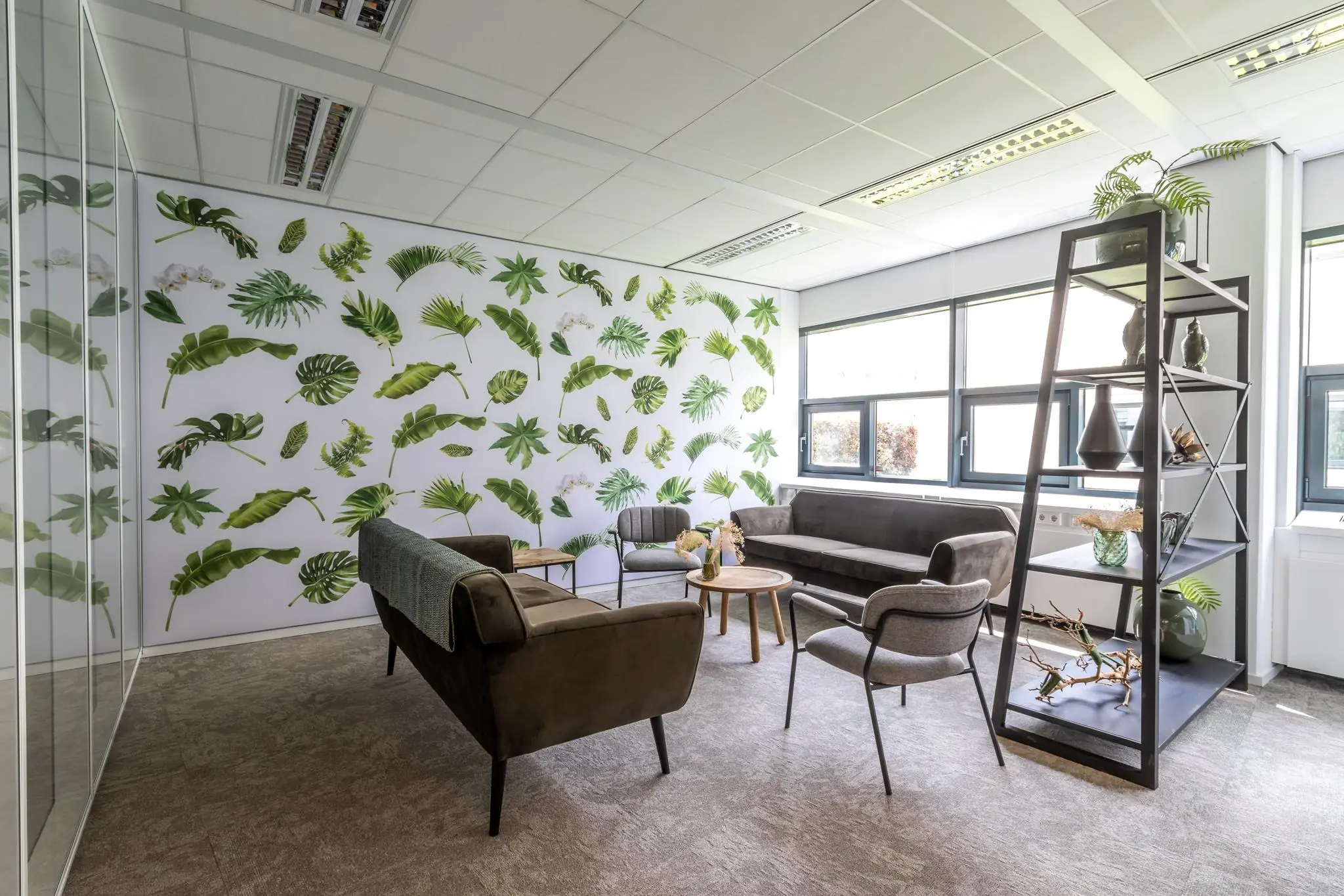 Moderne wachtruimte in Sparrenheuvel met natuurlijke wanddecoratie en comfortabele zitplaatsen.