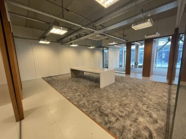 Moderne, deels gemeubileerde kantoorruimte aan de Danzigerkade met grote ramen en industriële plafondafwerking.