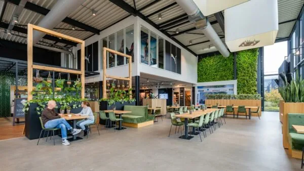 Moderne en groen ingerichte bedrijfsruimte aan de Plesmanstraat met zitgelegenheid, veel planten en een verticale tuin.