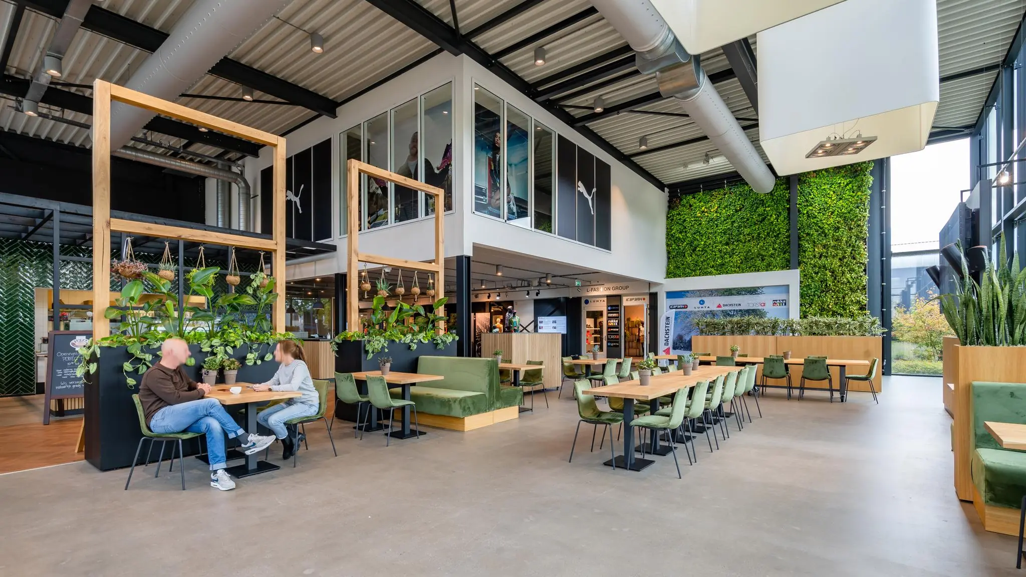 Moderne en groen ingerichte bedrijfsruimte aan de Plesmanstraat met zitgelegenheid, veel planten en een verticale tuin.