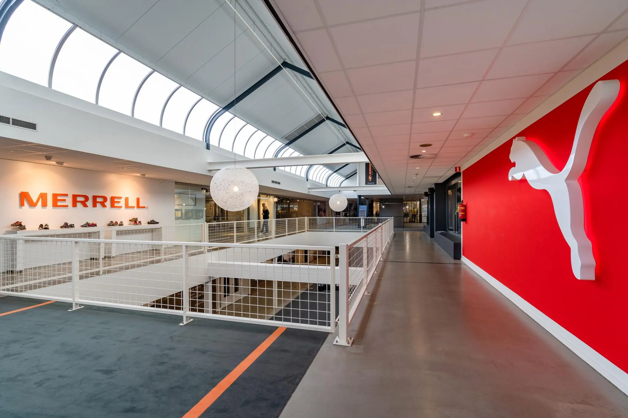 Moderne kantoorruimte aan de Plesmanstraat met opvallende Merrell en Puma merkpresentaties.