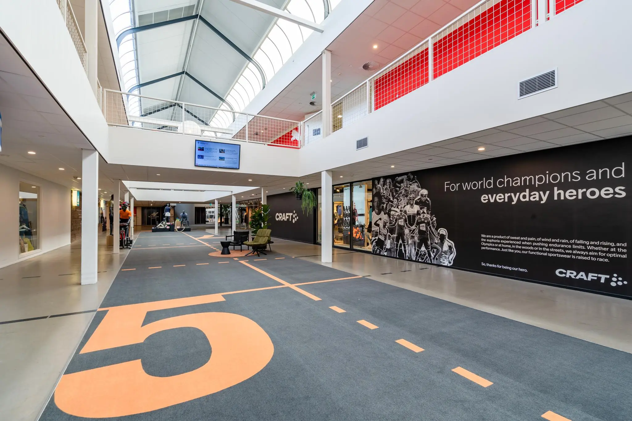 Moderne, lichte binnenruimte aan de Plesmanstraat met een sportieve uitstraling en een grote muurruimte van CRAFT met een inspirerende quote over helden en kampioenen.