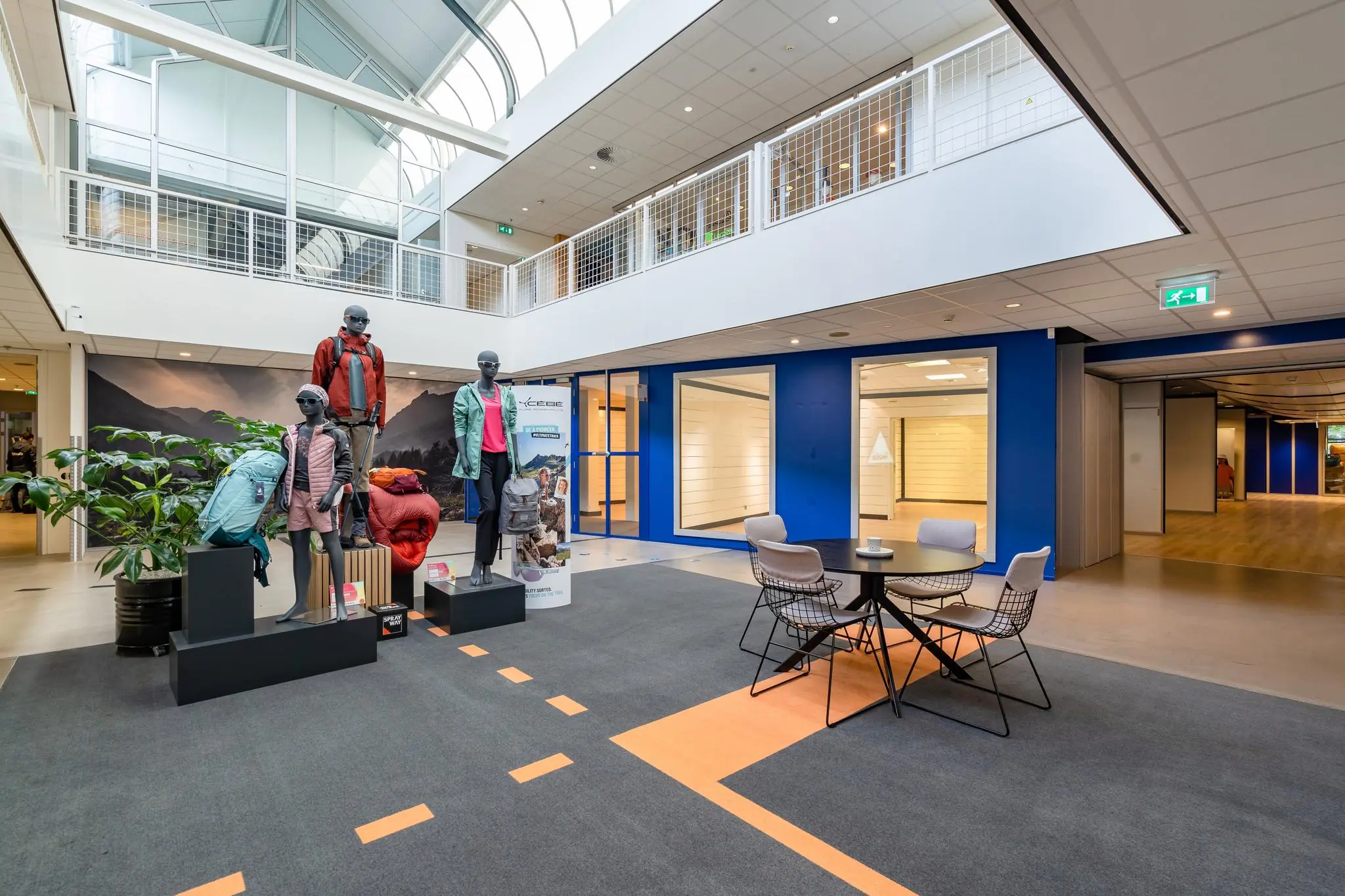 Moderne ontvangstruimte aan de Plesmanstraat met etalage van outdoor kleding en een zithoek.