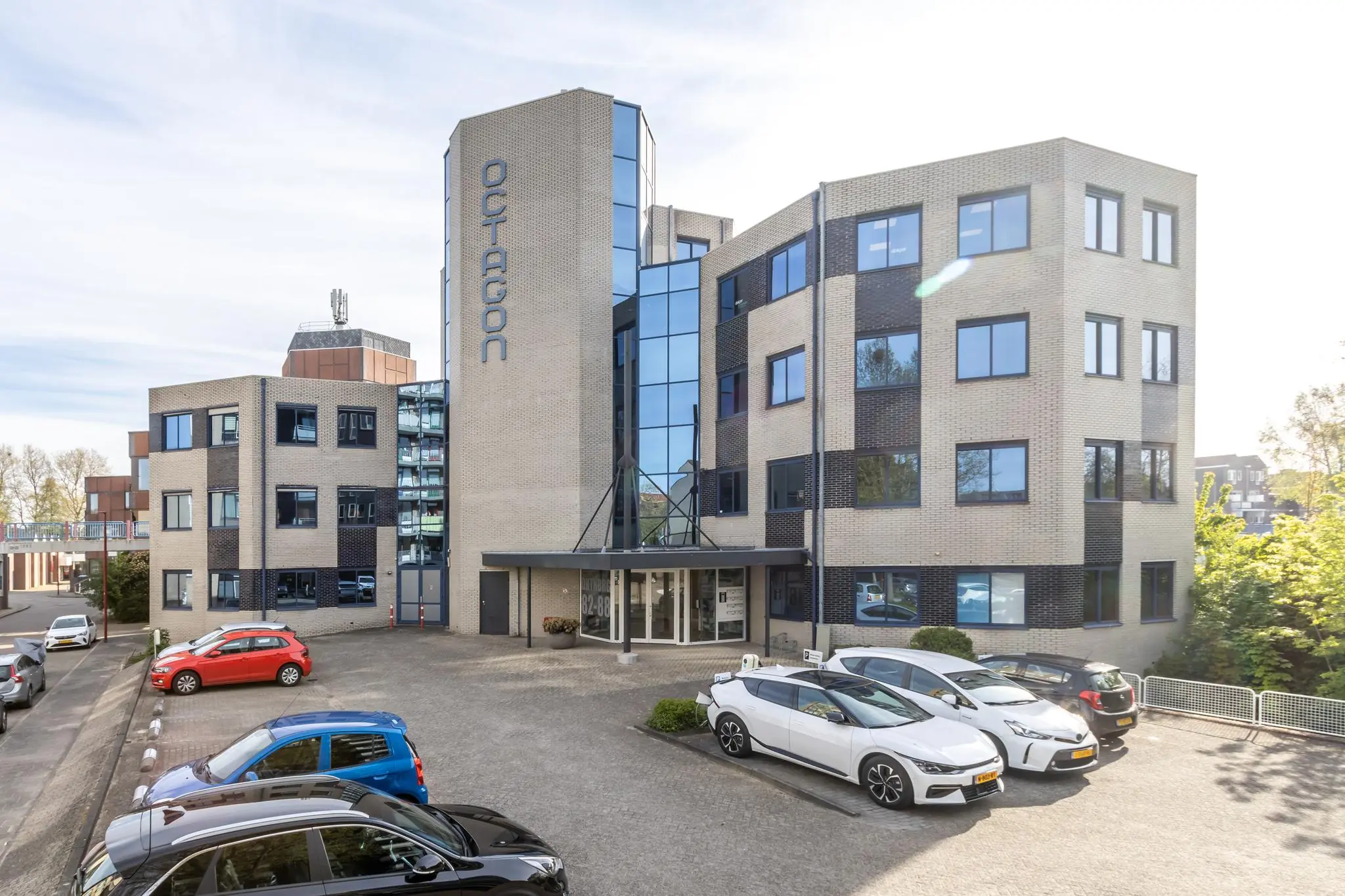 Kantoorpand Octagon aan de Dukatenburg met parkeerplaatsen op de voorgrond.