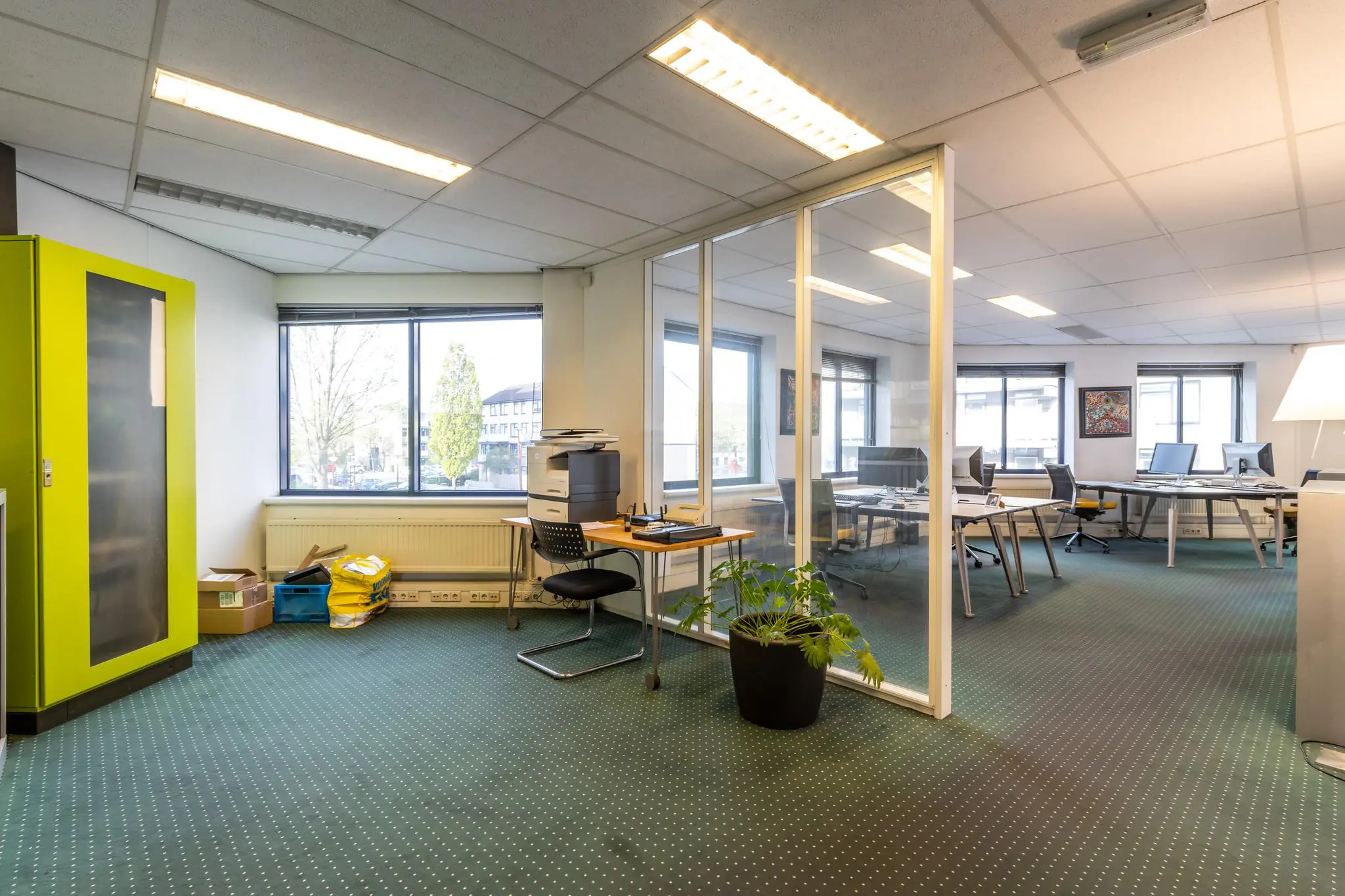 Modern kantoor met glazen scheidingswand, bureaus, kantoorstoelen en grote ramen aan de Dukatenburg.