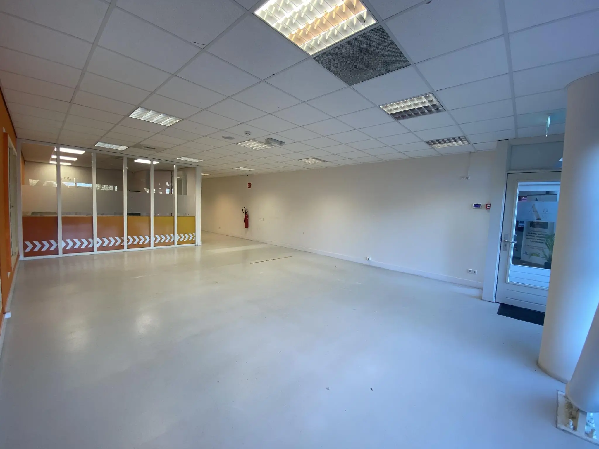 Leegstaand kantoorruimte op Herculesplein met glazen scheidingswand en oranje accenten.