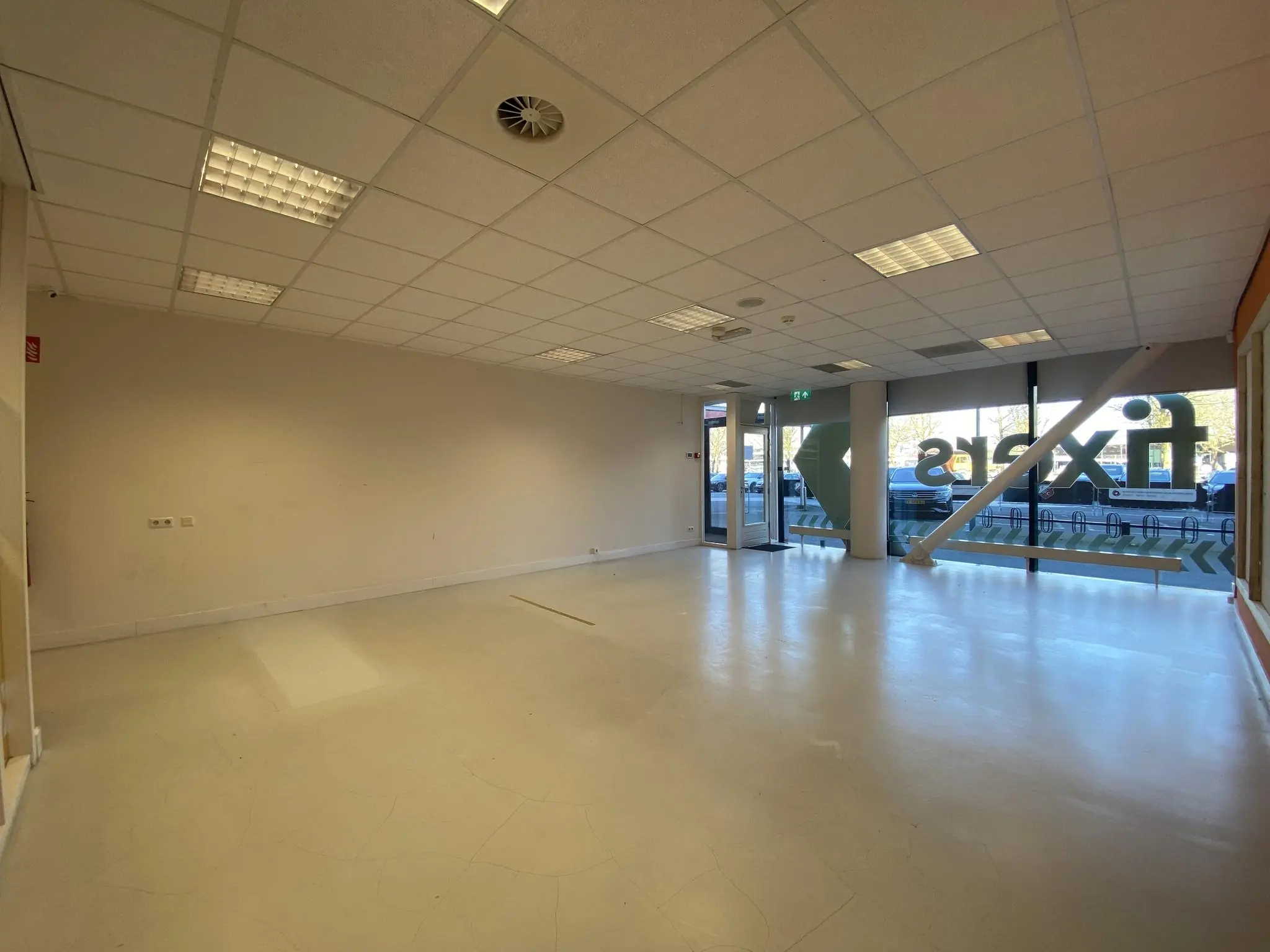 Leegstaand winkelpand aan het Herculesplein met grote raampartijen en systeemplafond.