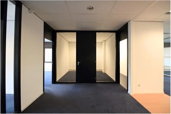 Moderne kantoorruimte aan het Herculesplein met zwart-witte wanden en blauwe vloerbedekking.