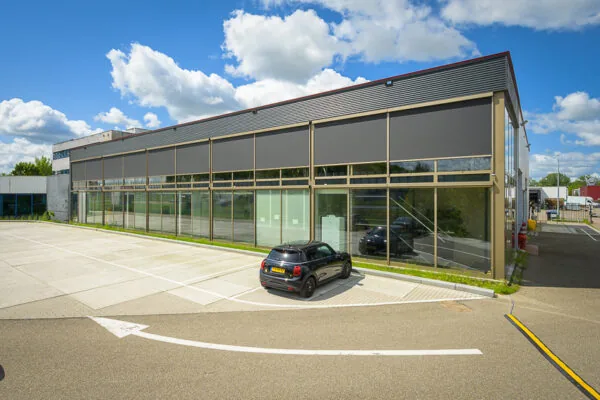 Zakelijk pand aan de Calandstraat met glazen gevel en geparkeerde zwarte auto op de voorgrond.