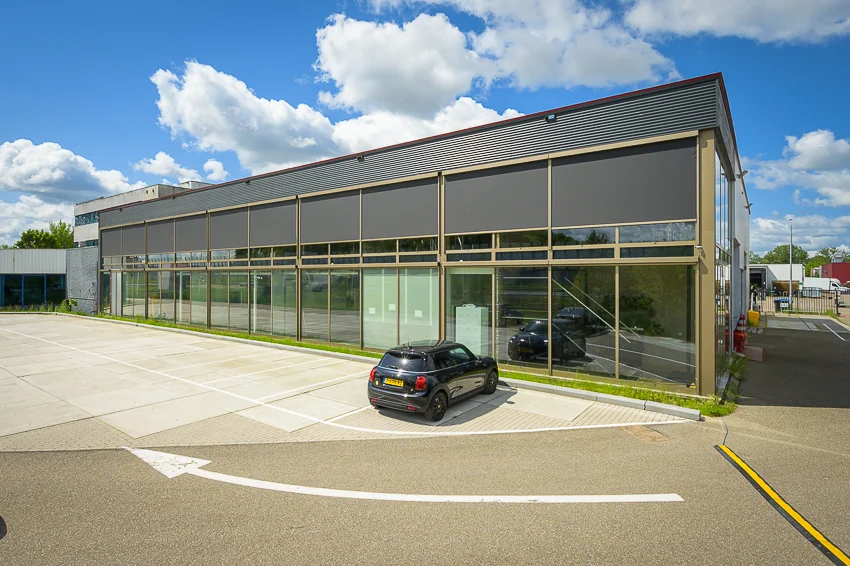 Zakelijk pand aan de Calandstraat met glazen gevel en geparkeerde zwarte auto op de voorgrond.