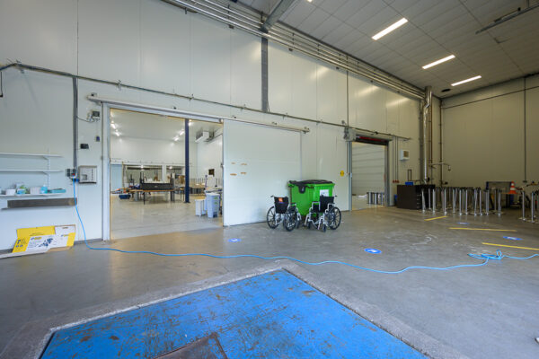 Rolstoeltoegankelijke industriële ruimte aan de Calandstraat met open schuifdeuren en zicht op de binnenruimte.