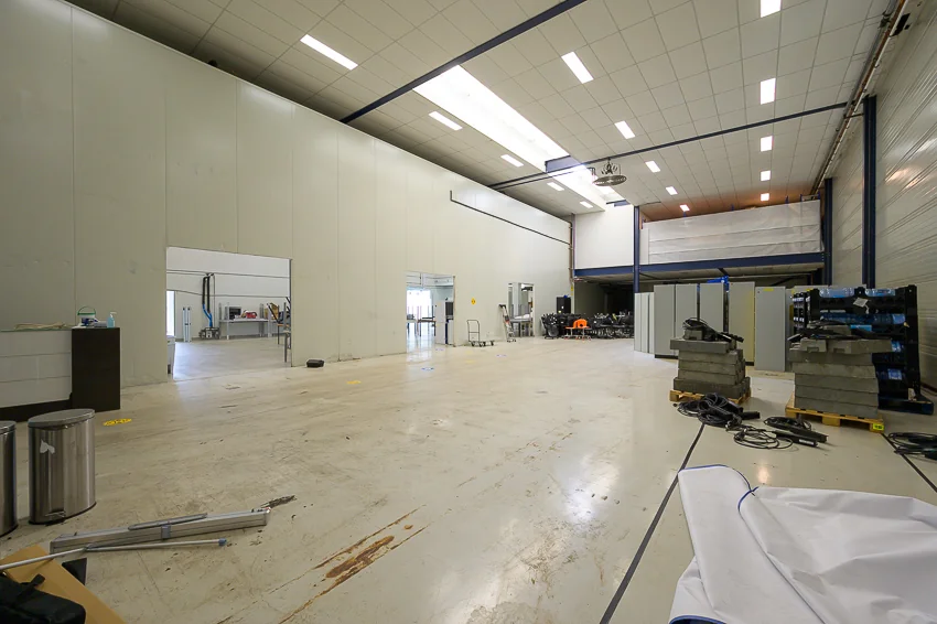 Ruime industriële loods aan de Calandstraat met hoge plafonds en opslagmaterialen.