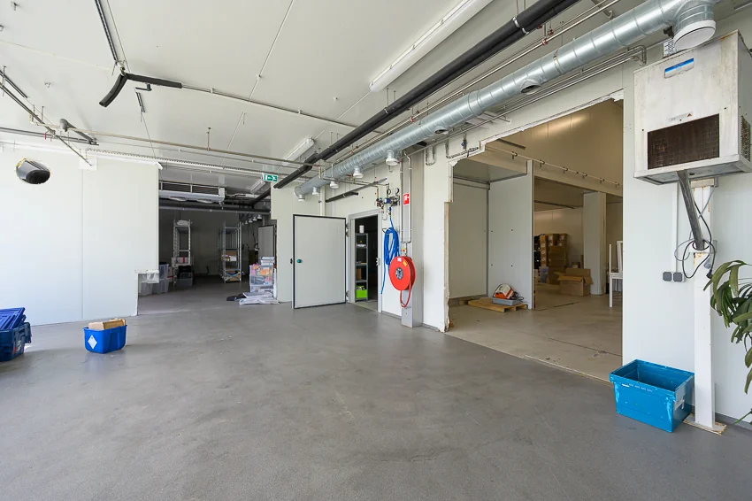 Ruime en nette bedrijfsruimte aan de Calandstraat met zicht op opslagruimtes en technische installaties.