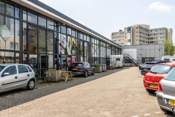 Bedrijfsverzamelgebouw aan de Eendrachtlaan met geparkeerde auto's en een glazen gevel.