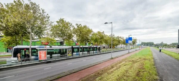 Tramhalte Stadion Feijenoord aan de Stadionweg met een stilstaande tram en wachtende passagiers.
