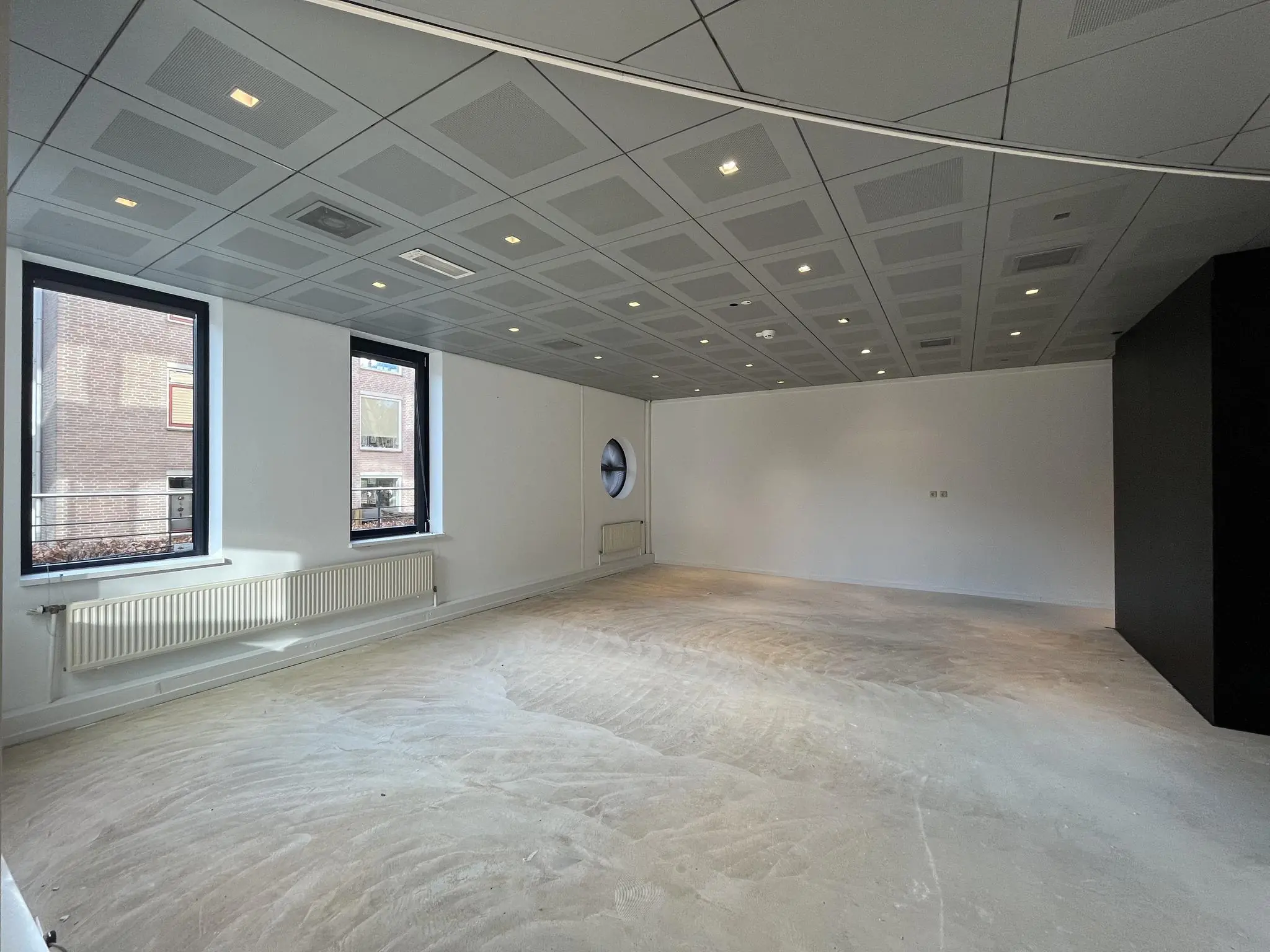 Leegstaand kantoorruimte aan de Amersfoortseweg met systeemplafond en grote ramen.