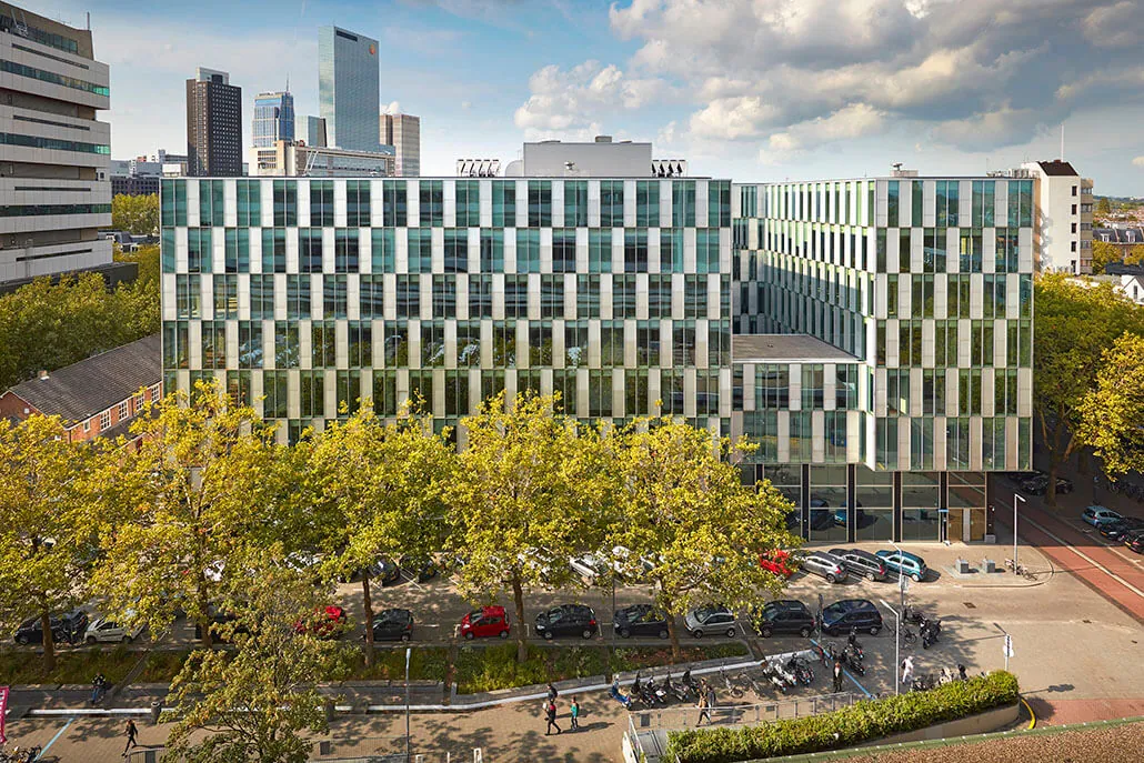 Modern kantoorgebouw aan de Benthemstraat in Rotterdam, omgeven door bomen en geparkeerde auto's.