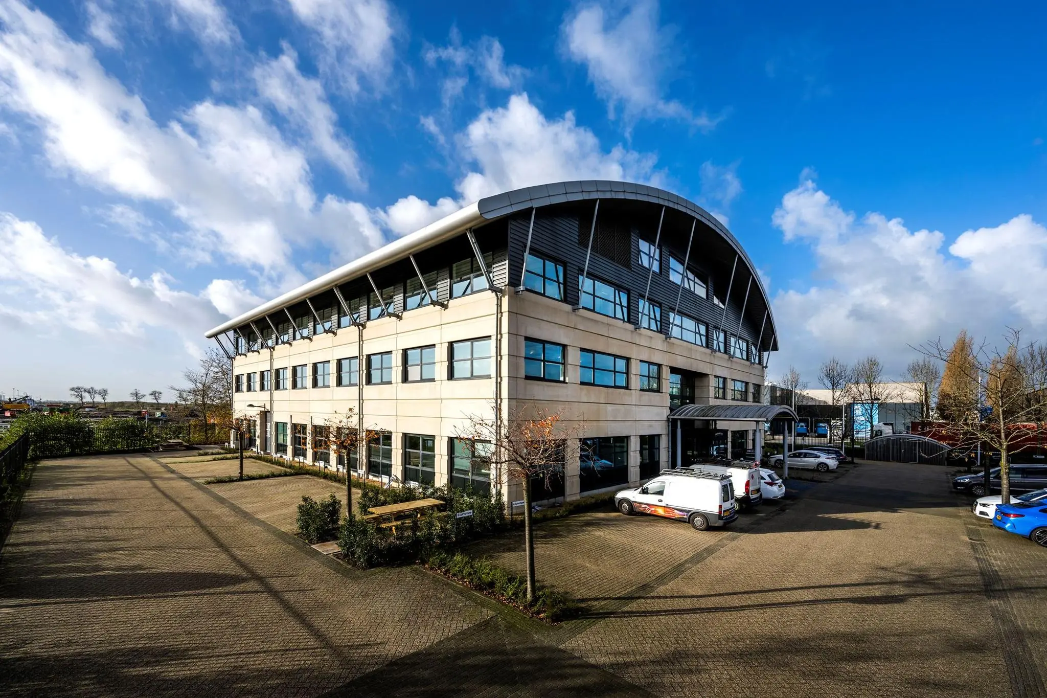 Modern kantoorgebouw aan de Singaporestraat met parkeergelegenheid en meerdere geparkeerde auto's.